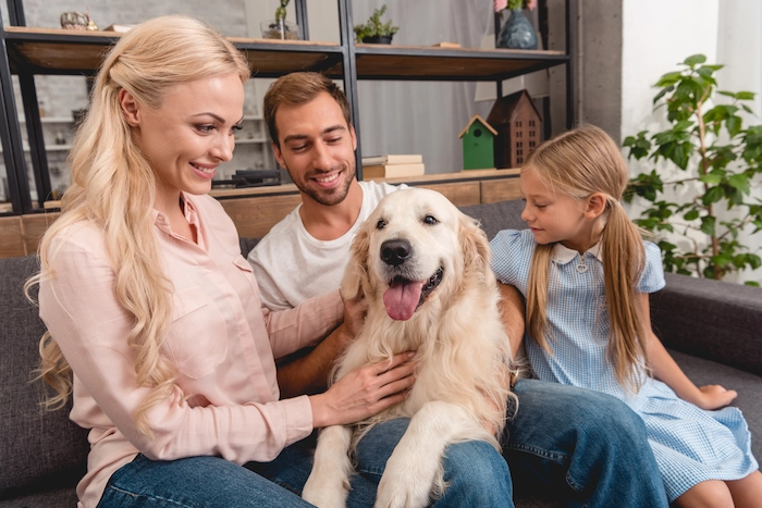 Parents with daughter playing with their adopted  dog