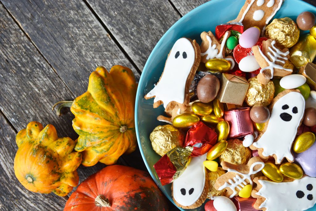 Halloween Jack-o-Lantern candy bowl with pumpkin sweets.